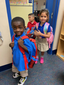 children in line with backpacks arriving to PreK