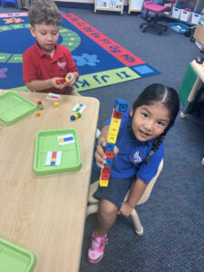 a boy and girl playing with blocks learning about math